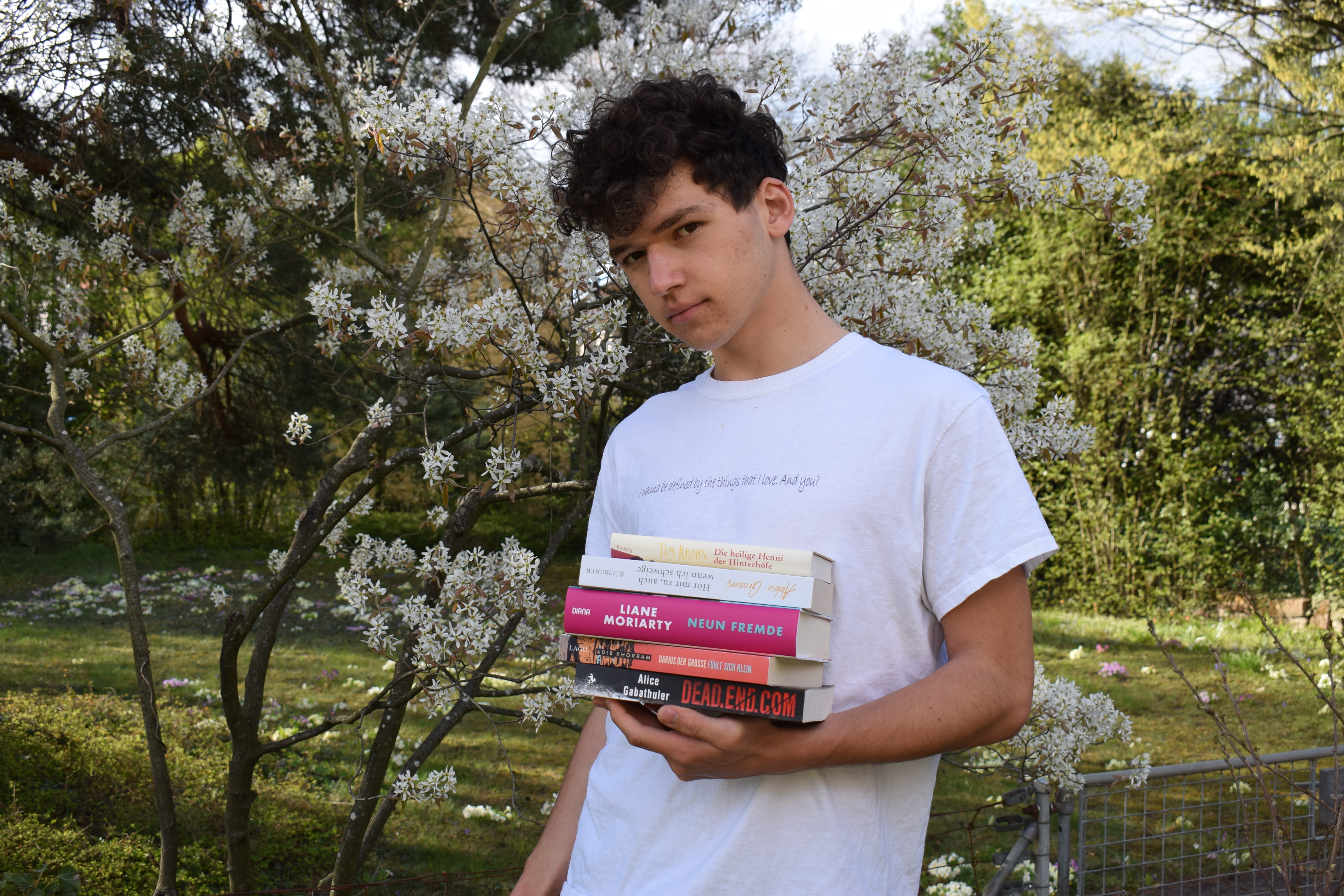 Monatsrückblick März 2021 - Josia Jourdan, young man standing outside with a stack of books